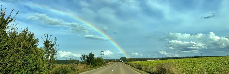 Freude über den Regenbogen am Horizont